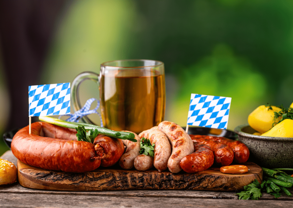 Bratwürste, Weißwürste und ein Bier mit bayerischen Fähnchen