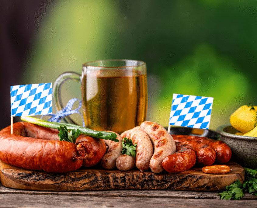 Bratwürste, Weißwürste und ein Bier mit bayerischen Fähnchen